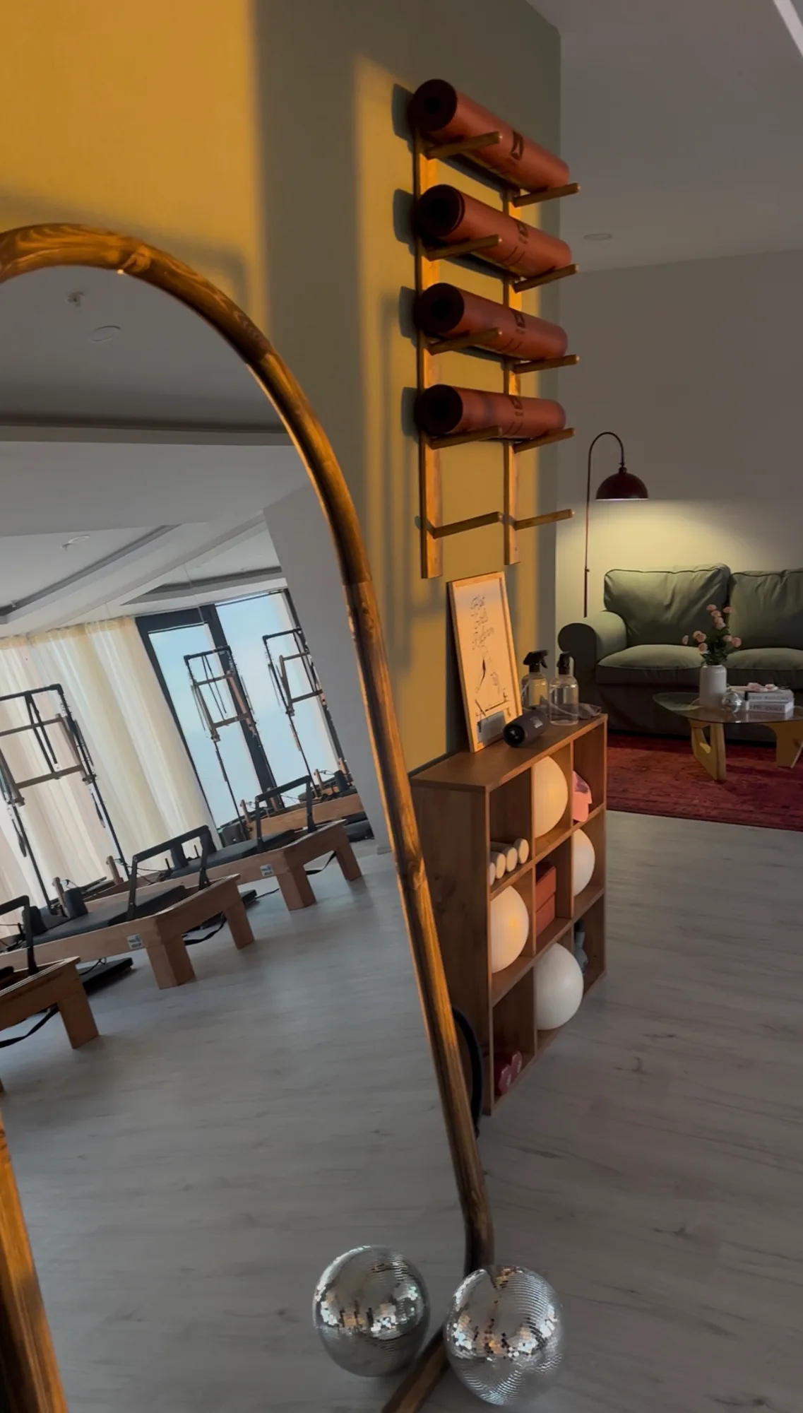 Aynada yansıyan salon; duvarda rulo matlar, yanında toplar ve dinlenme köşesi.